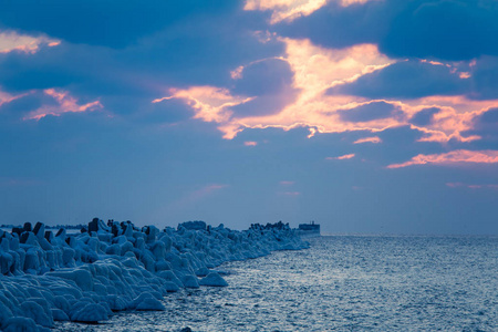 波罗的海一座冰冻防波堤的美丽夜景。海滩上的冬季景观。生动的色彩