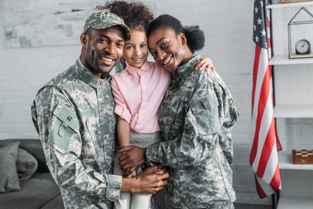 非洲裔美国男女士兵拥抱女儿