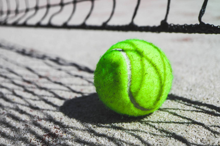 一个绿色网球球场上, 体育比赛的概念。网球网影子在球上。宏视图