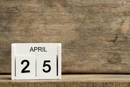 白色方块式日历当前日期25和月4月在木背景