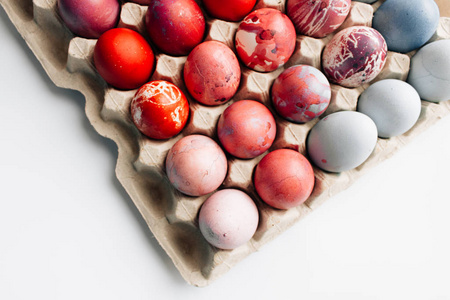 五颜六色的复活节彩蛋在鸡蛋纸盒白色背景, 节日背景