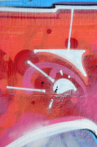 涂鸦画碎片。在街头艺术文化的风格上装饰着漆渍的旧墙。彩色背景纹理在温暖的色调