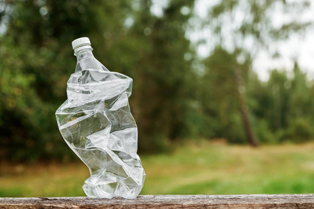 空塑料瓶上的木桌上的背景, 一个广泛的绿色性质。用于文本设计蒙太奇照片或广告的地方