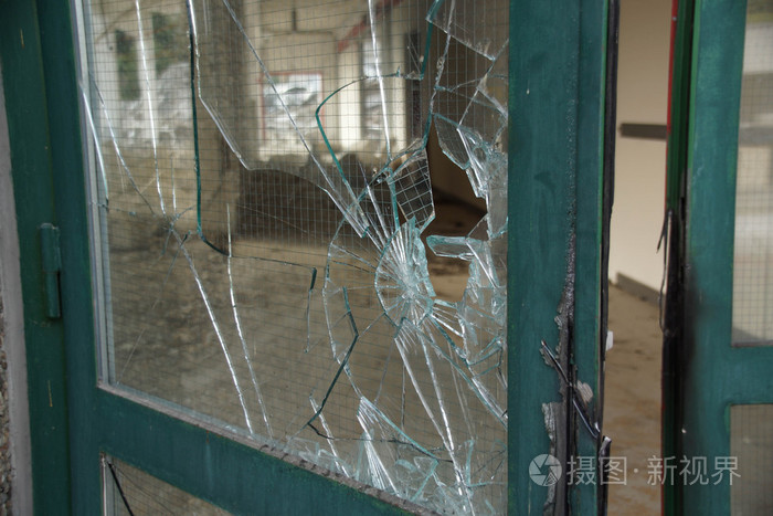 破碎的玻璃门与绿色的金属框架