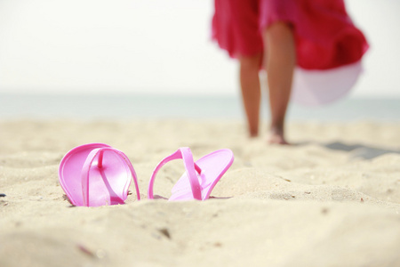拖鞋在海滩上的女孩
