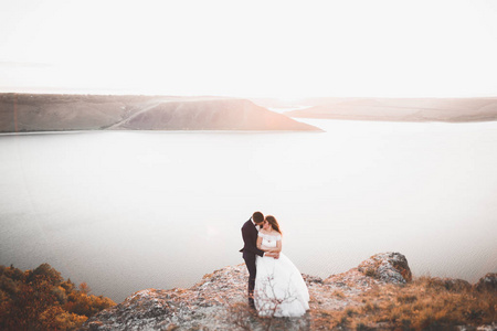 优雅时尚快乐新婚夫妇 新娘 海洋和天空的背景上的华丽新郎