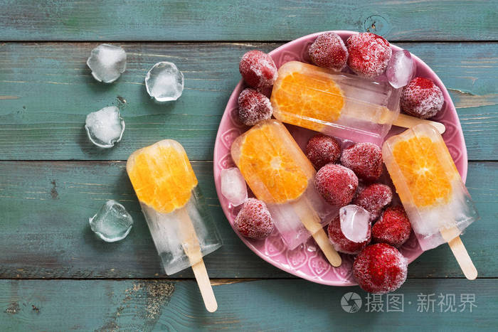 冰棒.新鲜水果冰淇淋, 橙色切片配有冰冻草莓, 冰块
