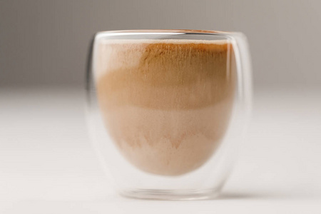 玻璃杯充满咖啡与牛奶在白色背景