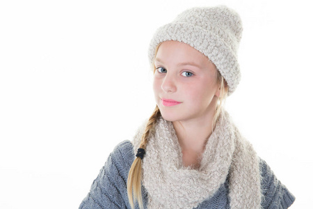 美丽的金发年轻女孩与围巾和羊毛帽在冬天