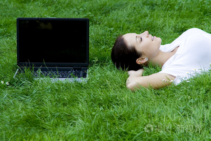 女人躺在草地上用的笔记本电脑