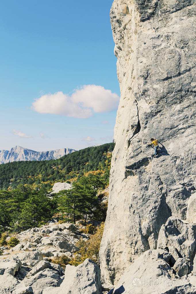 人攀岩者攀岩者爬上岩石墙.人使