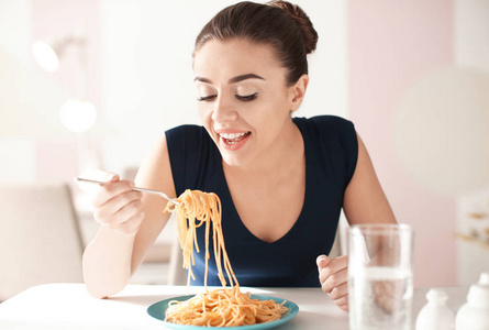 在咖啡馆吃可口的面食的年轻妇女