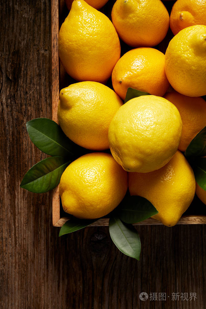 新鲜的柠檬水果在木制盒子上的木制餐桌上, 上面的景色.构图在角落里