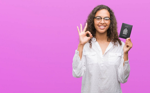 持有加拿大护照的年轻西班牙裔妇女做 ok 标志用手指, 优秀标志