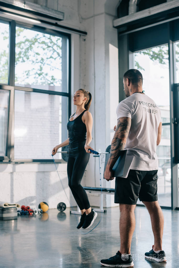 男性私人教练看运动员运动与跳绳在健身房照片-正版商用图片07537i-摄