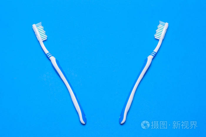 蓝色背景的两把牙刷口腔护理产品从顶部的视图平躺