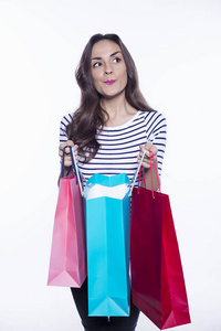 销售理念。购物微笑美丽的女人手持彩色购物袋在白色背景的休闲服装隔离。黑色星期五假期