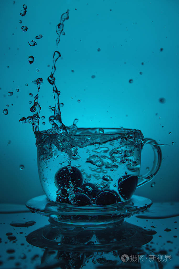 蓝色背景下杯中溅出的水