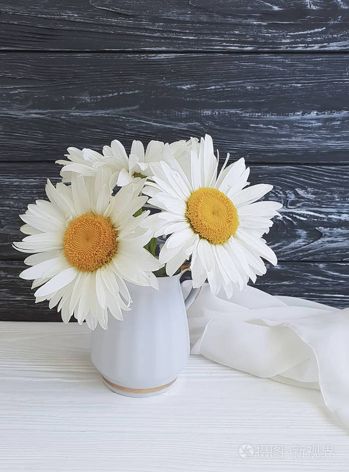 在木背景美丽的雏菊花瓶