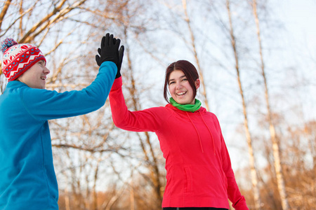 青年运动员下午在冬季公园握手的照片