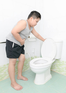 男孩在厕所,腹泻中遭受胃和呕吐照片