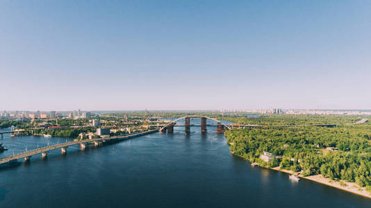 第聂伯河河的鸟瞰图。邮政区。桥。全景。森林。树。夏天。太阳。建筑。蓝色的水和天空。基辅。乌克兰