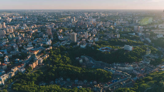 城市鸟瞰图。全景。许多建筑。耀眼的太阳。下摆。地平线。太阳照耀在树上。一天。夏天。基辅。自然。乌克兰