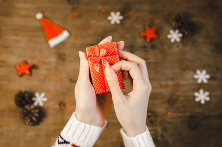 时尚的圣诞平躺在妇女手包装礼物。节日庆典概念妇女手打开红色礼品盒