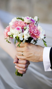 手和婚礼的花束上的戒指