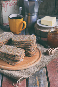 健康食品概念。早餐带 crispbreads, 黄油, 果酱, 咖啡。大饼饼干, 有芝麻, 亚麻籽, 南瓜和葵花籽。吃脆饼干。快