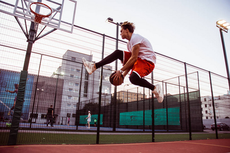 在户外篮球场上打篮球的青年男子全长照片