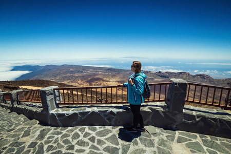 女孩在山之上云彩在山顶由火山 Teide, 特内里费岛, 加那利群岛, 西班牙