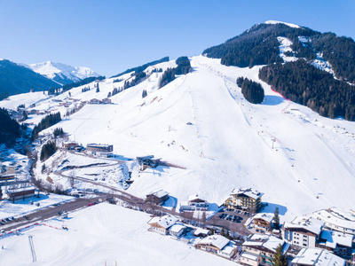 在阿尔卑斯的冬天村庄全景日出看法与滑雪胜地倾斜