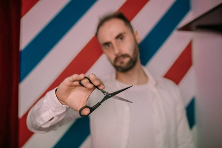 男理发师的肖像握着锋利的剪刀