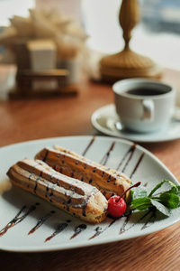 两个甜法式手指饼在盘子上。早餐在咖啡厅。木桌背景侧视图