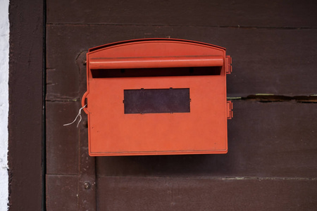 红色邮箱与褐色木背景
