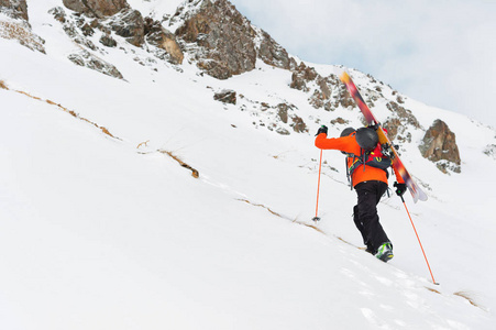 滑雪 freerider 爬上斜坡到深雪粉与设备上的背部固定在背包