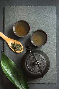绿色日本茶在黑色石板背景。具有复制空间的顶部视图