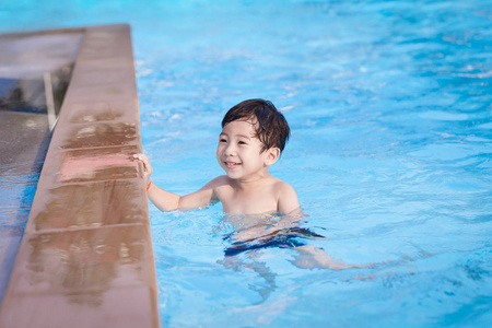 可爱的亚洲孩子玩游泳池细节