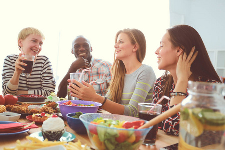 顶视图的一群人在一起时坐在木桌吃饭.在桌子上的食物.人们吃快餐照片