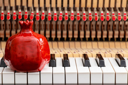 红色石榴在特写图片大钢琴钥匙和内部显示弦锤子和结构背景