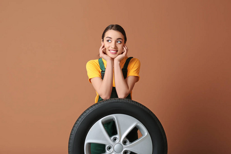 彩色背景汽车轮胎制服的女技工图片