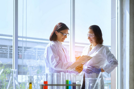 年轻的女科学家站在老师的实验室工人制造