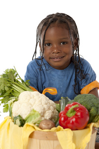 健康饮食。黑人小男孩抱着一个大篮子的蔬菜的安排