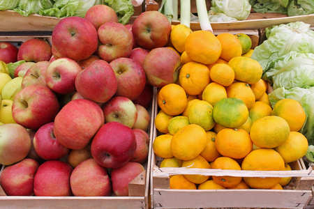 市场摊位新鲜有机红苹果和橙子