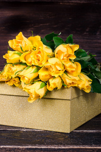 木制背景带礼盒的黄色玫瑰花