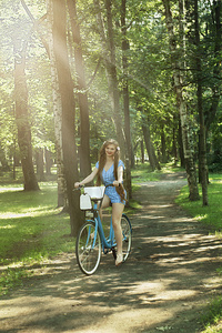 骑自行车在公园里的漂亮女孩