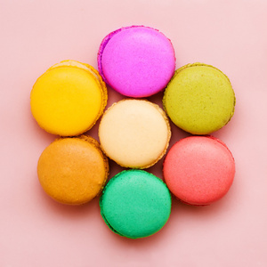 甜蜜多彩蛋白杏仁饼干，在粉色的背景下。顶视图