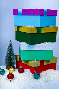 明亮的圣诞礼物和球在雪地上的蓝色背景。新年或圣诞节的装饰