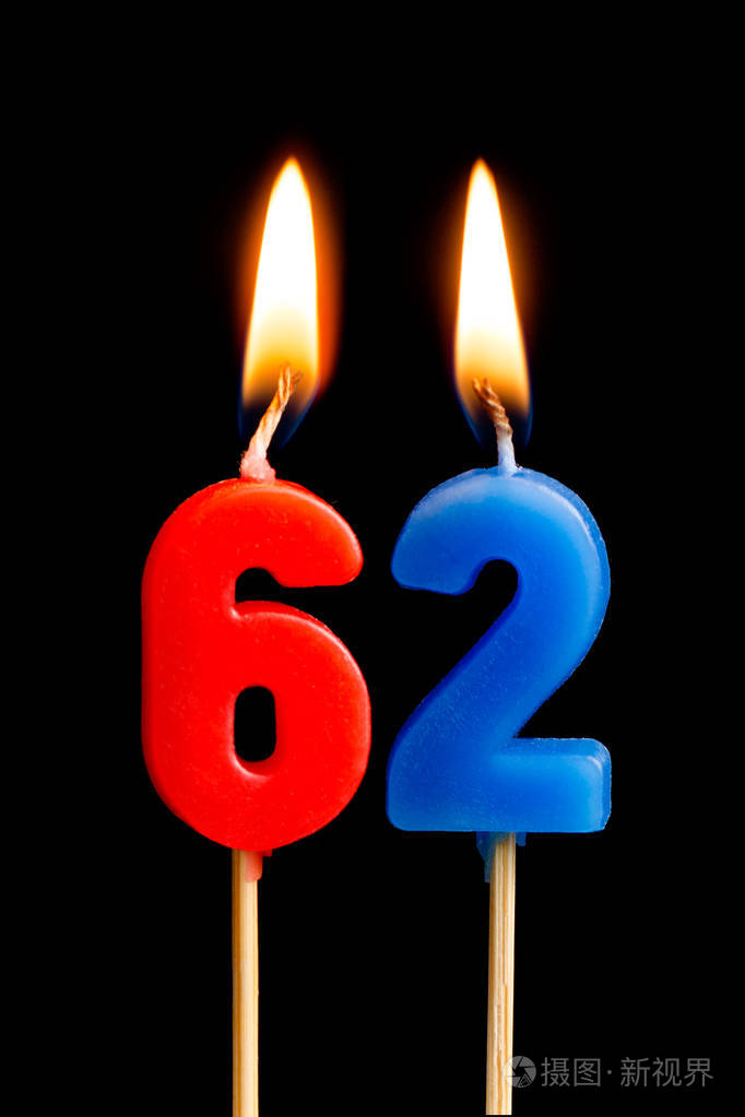 燃烧蜡烛的形式为62六十二 (数字, 日期) 的蛋糕孤立的黑色背景.